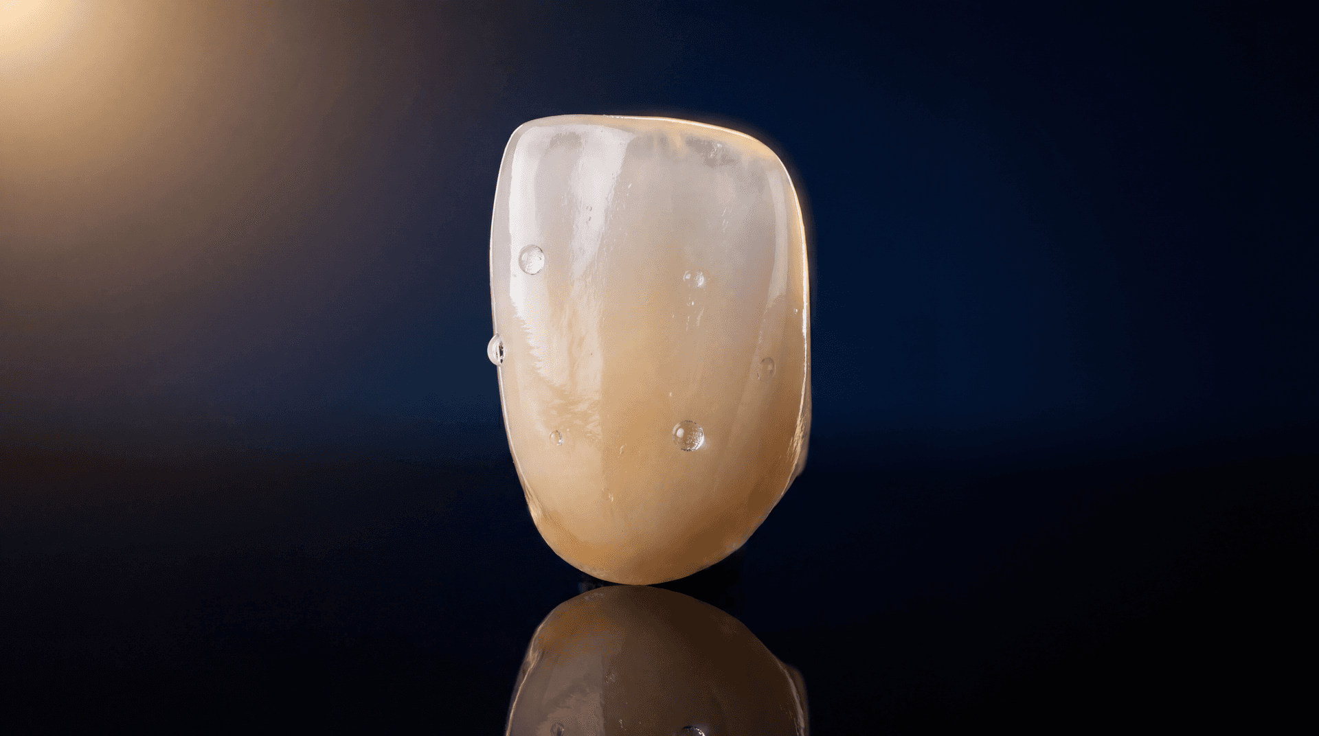 Lithium disilicate anterior crown with natural translucency and opalescence on pitch-black background